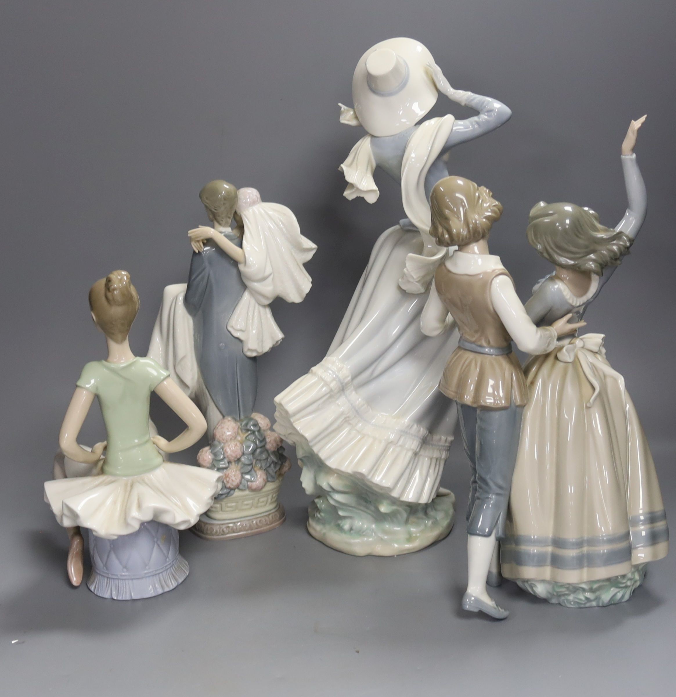 A Lladro figure of a ballet dancer, two dancers, newly-weds and lady in a bonnet, tallest 35cm